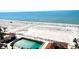 Aerial view of the beach, cabana, and empty community pool, with ocean views at 880 Mandalay Ave # N109, Clearwater Beach, FL 33767