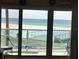 Balcony view of the beach and ocean through sliding glass doors at 880 Mandalay Ave # N109, Clearwater Beach, FL 33767