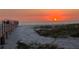 Scenic beach view with a boardwalk and stunning sunset over the ocean at 880 Mandalay Ave # N109, Clearwater Beach, FL 33767
