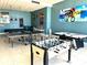 Large game room featuring ping pong, foosball, and pool tables with cozy seating and artwork at 880 Mandalay Ave # N109, Clearwater Beach, FL 33767