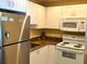 Clean kitchen featuring white appliances and light-colored cabinets at 880 Mandalay Ave # N109, Clearwater Beach, FL 33767