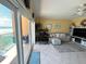 Living room with a desk and large sliding glass doors leading to a balcony overlooking the ocean at 880 Mandalay Ave # N109, Clearwater Beach, FL 33767