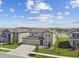 A neighborhood view showcasing a two-story home with a well manicured front yard with water feature in background at 9287 Crescent Ray Dr, Wesley Chapel, FL 33545