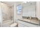 The bright bathroom offers granite countertops, a modern sink, decorative fixtures and a shower/tub combo at 9287 Crescent Ray Dr, Wesley Chapel, FL 33545