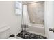 Neutral bathroom featuring white tub and shower, shower curtain, and grey tile surround at 9287 Crescent Ray Dr, Wesley Chapel, FL 33545