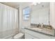 Bright bathroom with granite countertop, modern fixtures, shower with curtain, and neutral tones at 9287 Crescent Ray Dr, Wesley Chapel, FL 33545