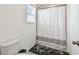 Bright bathroom features a shower with white curtain and a window letting in natural light at 9287 Crescent Ray Dr, Wesley Chapel, FL 33545