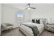 The modern bedroom has a large bed with stylish bedding, a sleek ceiling fan and lots of natural light at 9287 Crescent Ray Dr, Wesley Chapel, FL 33545