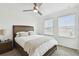 This modern bedroom has a large bed with stylish bedding, ceiling fan, neutral walls and lots of natural light at 9287 Crescent Ray Dr, Wesley Chapel, FL 33545