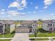 This beautiful two-story home boasts a three-car garage, lush landscaping, and a serene water view at 9287 Crescent Ray Dr, Wesley Chapel, FL 33545