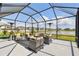 Screened in patio featuring comfortable outdoor seating and views of the pond and surrounding community at 9287 Crescent Ray Dr, Wesley Chapel, FL 33545