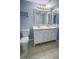 Well-lit bathroom with a double sink vanity, framed mirror and convenient toilet placement at 9516 Newdale Way # 101, Riverview, FL 33578