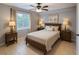 Well-lit bedroom with a queen-size bed, neutral decor, and stylish side tables with lamps at 9516 Newdale Way # 101, Riverview, FL 33578