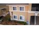 View of a beige apartment building featuring white framed windows, stairs and well-manicured landscaping at 9516 Newdale Way # 101, Riverview, FL 33578