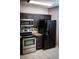 Efficient kitchen space featuring stainless steel appliances, dark cabinetry, and modern fixtures at 9516 Newdale Way # 101, Riverview, FL 33578