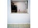 Open kitchen pass-through with granite countertop, dark cabinets, and a view of the kitchen appliances at 9516 Newdale Way # 101, Riverview, FL 33578