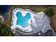 Aerial view of a unique pool with ample seating and recreational space beside a picturesque lake at 9516 Newdale Way # 101, Riverview, FL 33578