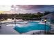A unique community pool with ample seating and recreational space beside a picturesque lake at sunset at 9516 Newdale Way # 101, Riverview, FL 33578