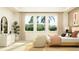 Serene bedroom with large windows, a comfortable bed, and elegant decor for a relaxing retreat at 9657 Runaway Breeze Dr, Land O Lakes, FL 34637