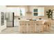Modern kitchen featuring white cabinets, stainless steel appliances, and a center island with seating at 9657 Runaway Breeze Dr, Land O Lakes, FL 34637