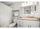 Neat bathroom featuring a vanity sink, toilet, and a storage shelf for towels and toiletries at 10100 Sailwinds N Blvd # 105, Largo, FL 33773