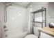 Clean bathroom featuring a shower-tub combo, storage shelves, and a vanity sink with ample lighting at 10100 Sailwinds N Blvd # 105, Largo, FL 33773
