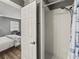 Bathroom with glass shower, white subway tile, and a peek into the bedroom at 10100 Sailwinds N Blvd # 105, Largo, FL 33773