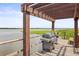 Grill and bench on wooden dock overlooking lake with waterlilies at 10100 Sailwinds N Blvd # 105, Largo, FL 33773