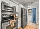 Updated kitchen featuring stainless steel appliances, tile floors, and white cabinets at 10100 Sailwinds N Blvd # 105, Largo, FL 33773