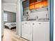 Laundry room with washer, dryer, cabinets, and adjacent bedroom at 10100 Sailwinds N Blvd # 105, Largo, FL 33773