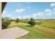 Scenic backyard view with lush green grass, mature trees, and a serene pond at 10420 Echo Dock Loop, San Antonio, FL 33576