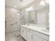 Bright bathroom featuring a double vanity, large mirror, recessed lighting, a tiled walk-in shower and accessibility features at 10420 Echo Dock Loop, San Antonio, FL 33576