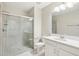 This bright bathroom features a large mirror, a vanity with a single sink, and a glass-enclosed walk-in shower at 10420 Echo Dock Loop, San Antonio, FL 33576