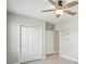 Bright bedroom featuring a ceiling fan with lights, tile flooring, closet space, and an adjoining room at 10420 Echo Dock Loop, San Antonio, FL 33576