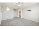 Carpeted bedroom featuring a ceiling fan with lights, decorative lights, and an adjoining bathroom at 10420 Echo Dock Loop, San Antonio, FL 33576