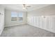 This bright bedroom offers carpet flooring, a ceiling fan, decorative lights, and natural light from two windows at 10420 Echo Dock Loop, San Antonio, FL 33576