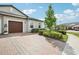Paver driveway leading to a well-maintained home with neat landscaping at 10420 Echo Dock Loop, San Antonio, FL 33576
