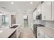 Open kitchen with white cabinets, stainless steel appliances, and a large island at 10420 Echo Dock Loop, San Antonio, FL 33576