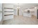 Spacious open-concept kitchen featuring white cabinets, stainless appliances, and large tile flooring at 10420 Echo Dock Loop, San Antonio, FL 33576