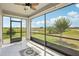 The screened lanai features tile flooring, a ceiling fan, and views of a lawn with a pond at 10420 Echo Dock Loop, San Antonio, FL 33576