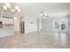 Open-concept living room boasts tile floors, a modern ceiling fan and light fixtures, and sliding glass doors to the outside at 10420 Echo Dock Loop, San Antonio, FL 33576