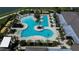 Aerial view of a uniquely designed community pool surrounded by lounge chairs, palm trees, and a tiki bar at 10420 Echo Dock Loop, San Antonio, FL 33576