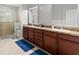 Bright bathroom featuring double sinks, wood cabinetry, shower and tile flooring at 11308 Temperley Pl, Tampa, FL 33625