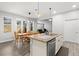 Open kitchen with granite island, stainless steel appliances, dining area, and hardwood flooring at 11308 Temperley Pl, Tampa, FL 33625