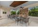 Outdoor kitchen features a stone surround, ceiling fans and outdoor dining area at 11308 Temperley Pl, Tampa, FL 33625