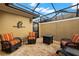 Screened patio with stone flooring, wicker furniture, ceiling and outdoor lighting at 11308 Temperley Pl, Tampa, FL 33625