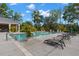 Community pool featuring lounge chairs, lush landscaping and covered outdoor kitchen at 11308 Temperley Pl, Tampa, FL 33625
