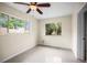 Bright bedroom showcasing neutral walls, tile flooring, a ceiling fan, and generously sized windows offering ample natural light at 115 S Saturn Ave, Clearwater, FL 33755