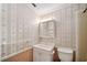 Traditional bathroom featuring a vanity, toilet, mirror, and classic patterned wallpaper at 11514 Sun Rd, Dade City, FL 33525