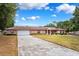 Inviting brick facade with manicured lawn, long driveway, and attached two-car garage at 11514 Sun Rd, Dade City, FL 33525